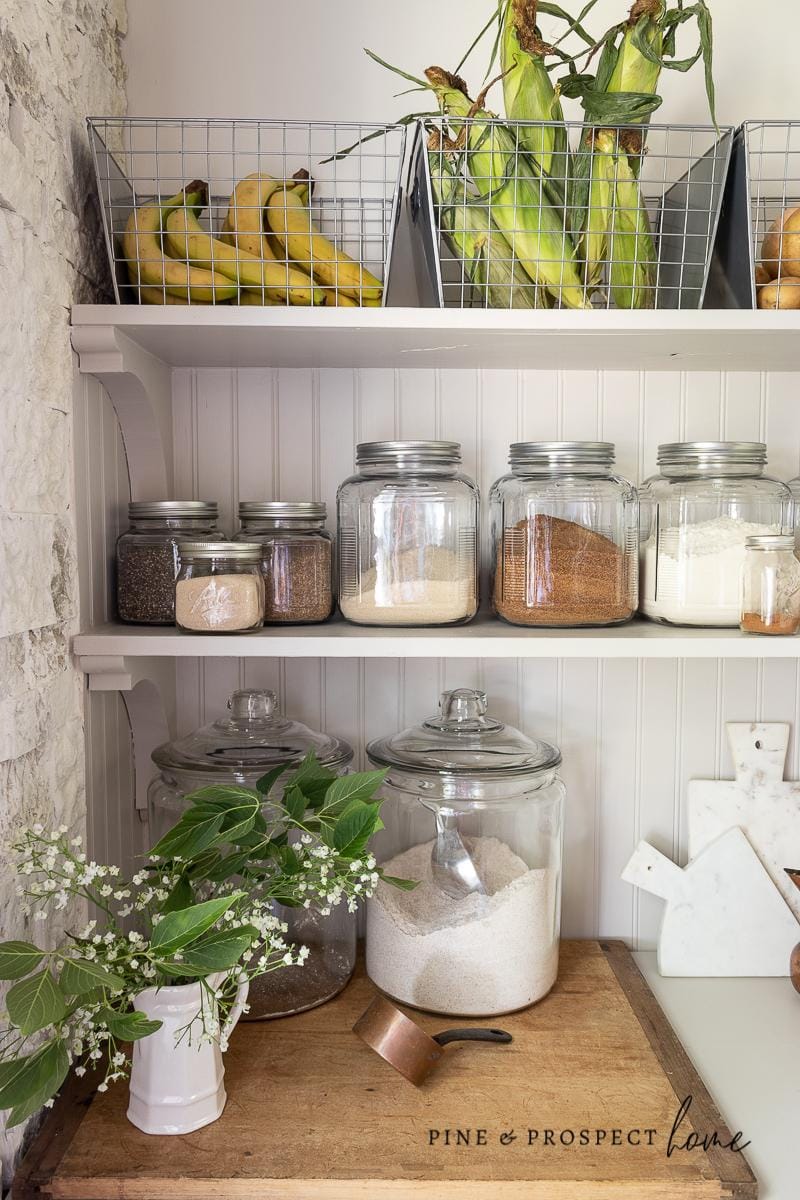 Neatly organized pantry shelves with glass jars